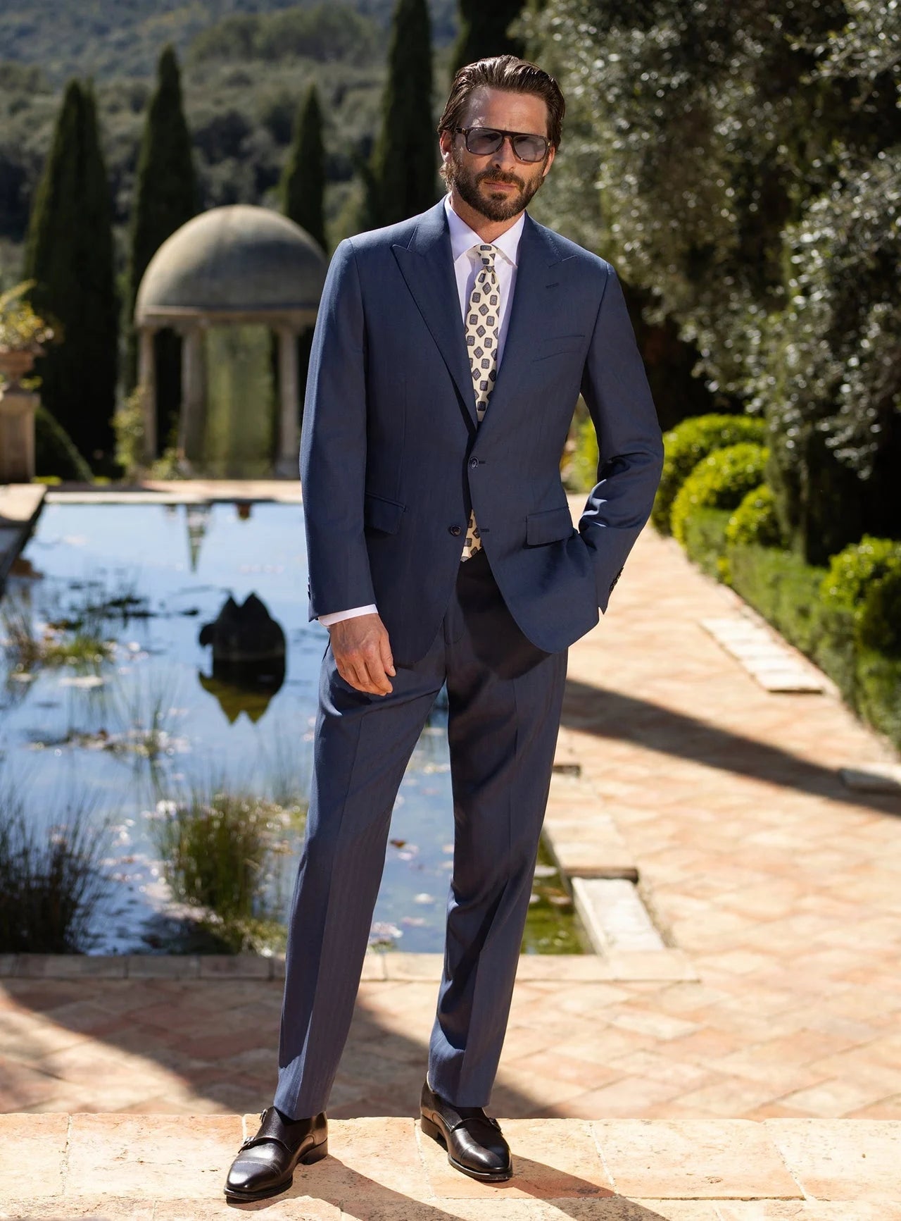 Costum masculin bleumarin Consiglieri, cu cămașă albă și cravată, în grădină